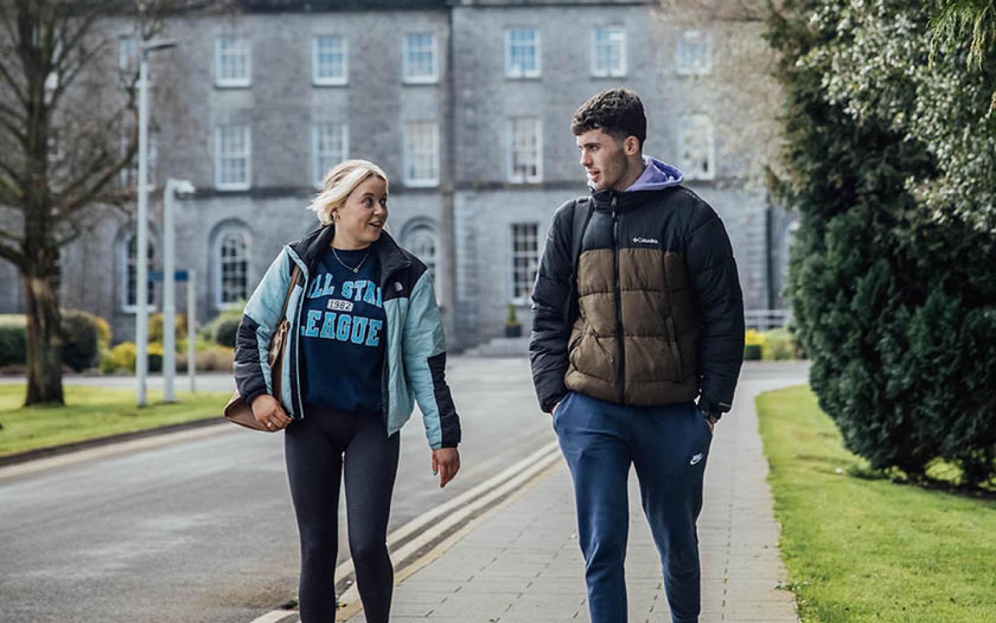 Two students walking in front of the main building at MIC Thurles