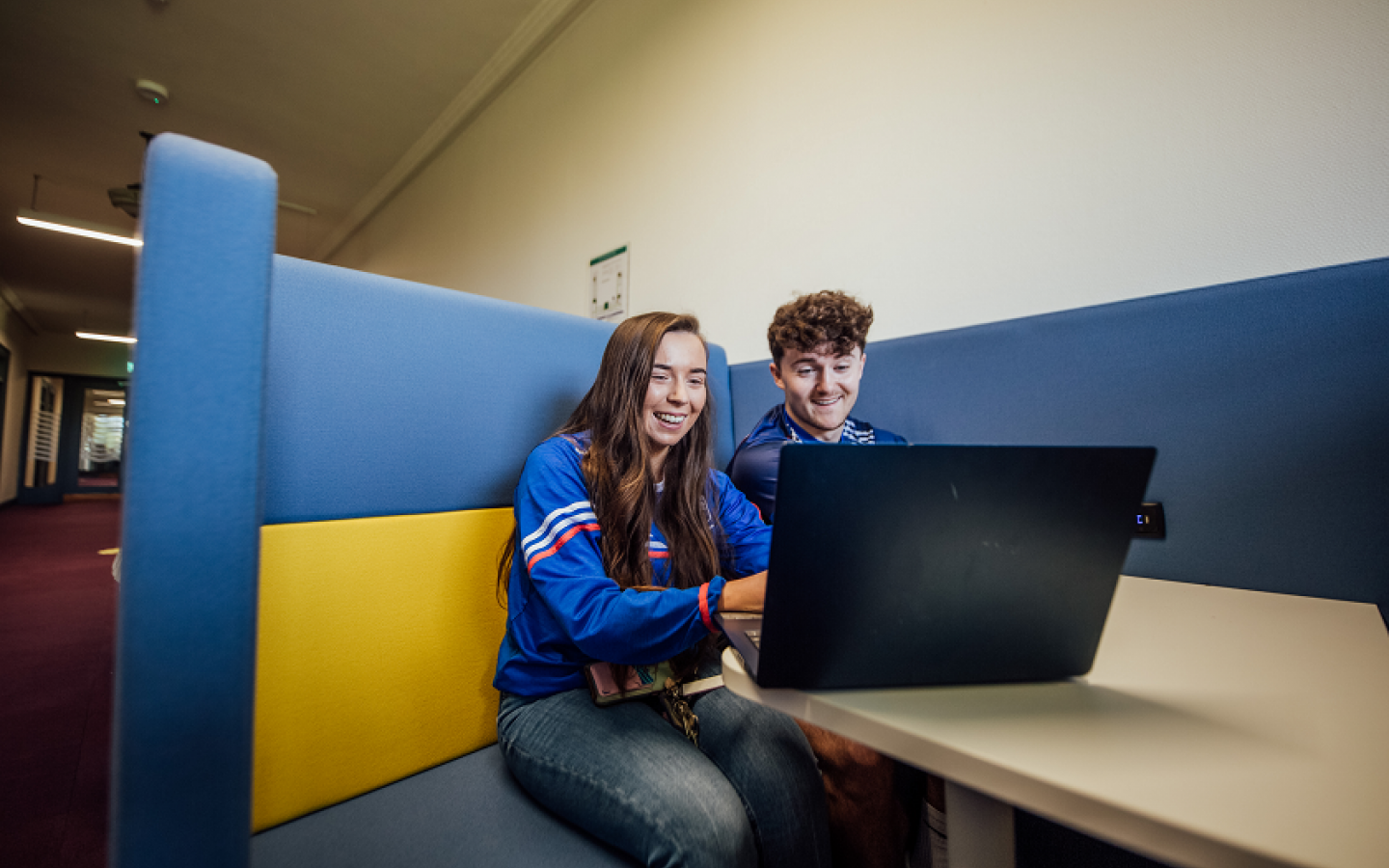 Two students working at a laptop