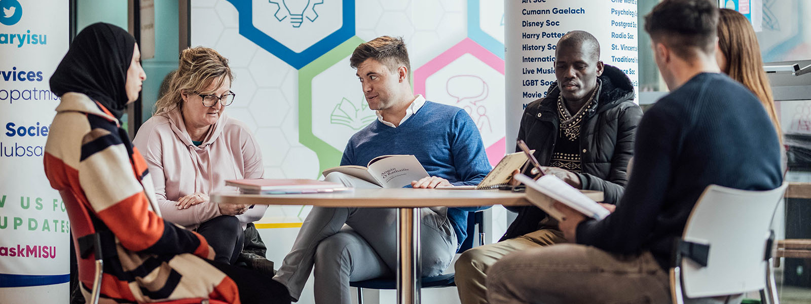 Six postgraduate students sitting in the student lounge in the Tara building at MIC Limerick.