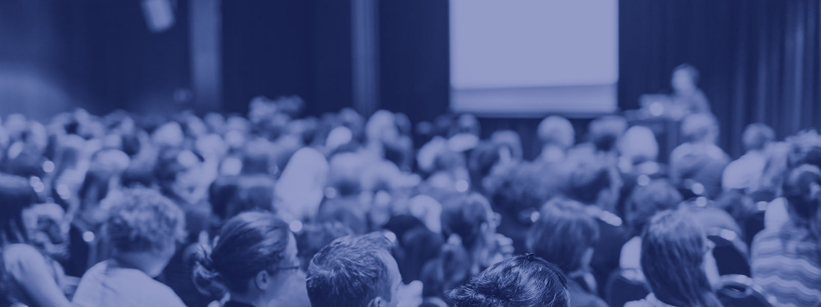 Students attending a lecture in a large lecture hall - picture taken from behind the students.