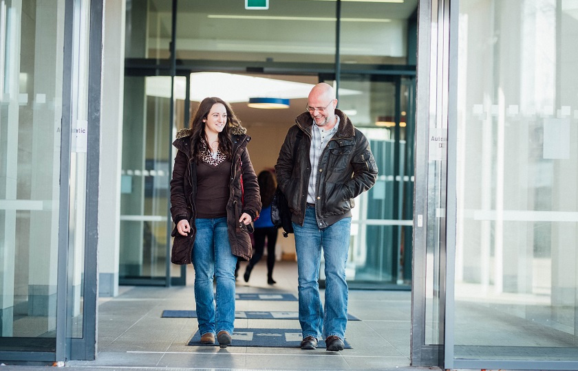 Two mature students walking out main door to Foundation Building MIC Limerick