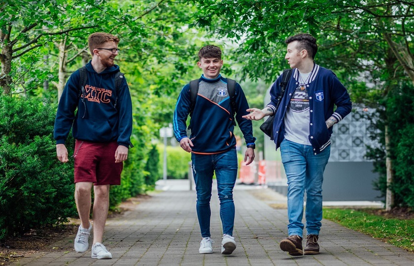 three male students talking and walking through the MIC Limerick campus