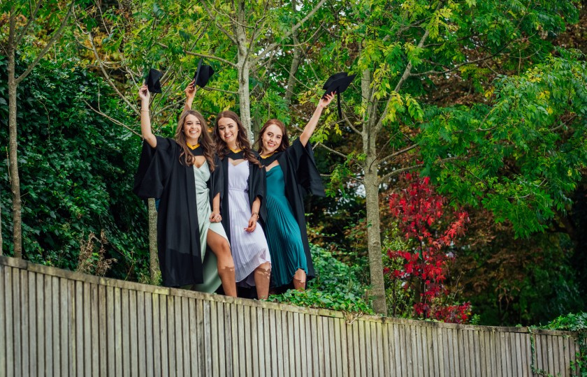 Three MIC students wave to camera