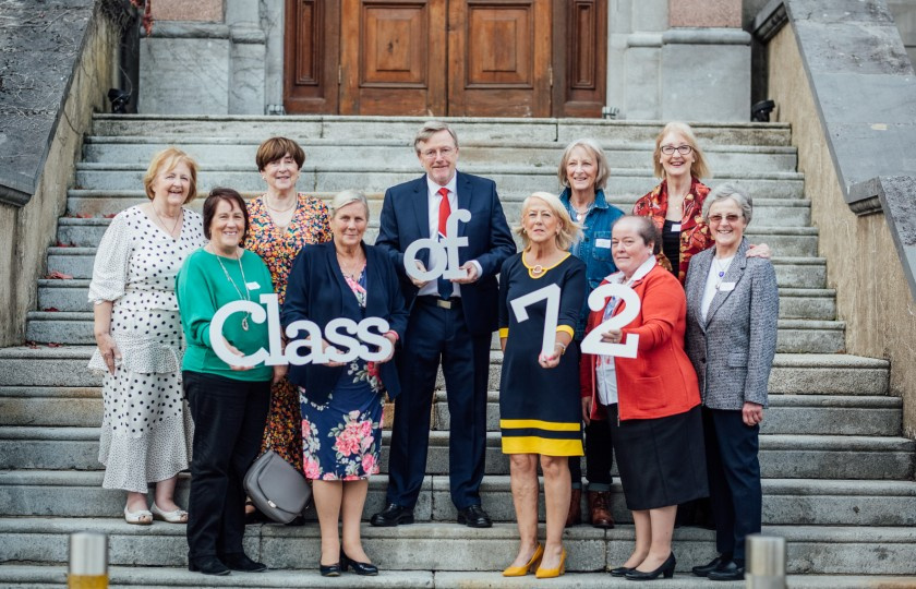 Alumni standing on steps with Professor Eugene Wall