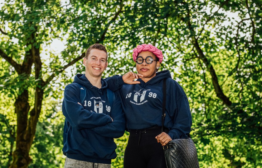 Male and female student standing in front of trees at MIC's Limerick campus