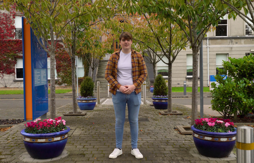 Student supports video thumbnail  of male student standing in front of MIC main building