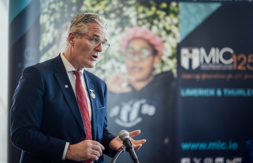 President Jarlath Burns speaking in front of MIC branded background