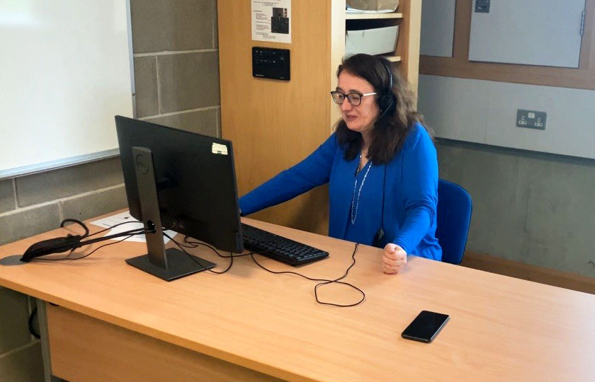 Woman sitting at a desk working on a desktop computer.