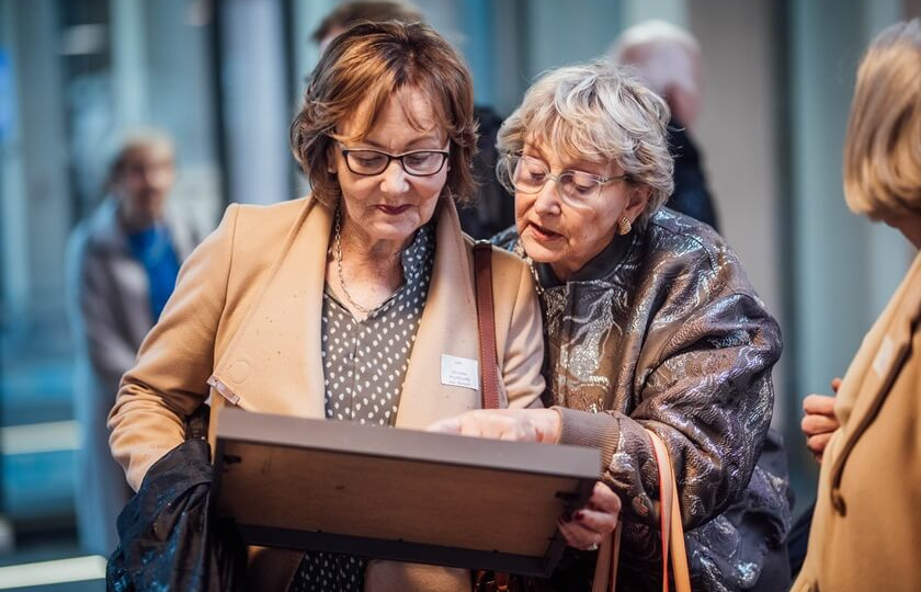 MIC Alumni Reunion 2024 two ladies looking at a photograph