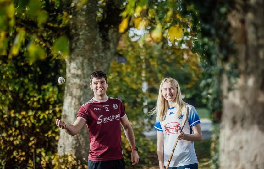 GPA Scholarship recipients Eoin Lawless and Niamh Murphy playing with a hurley and sliotar