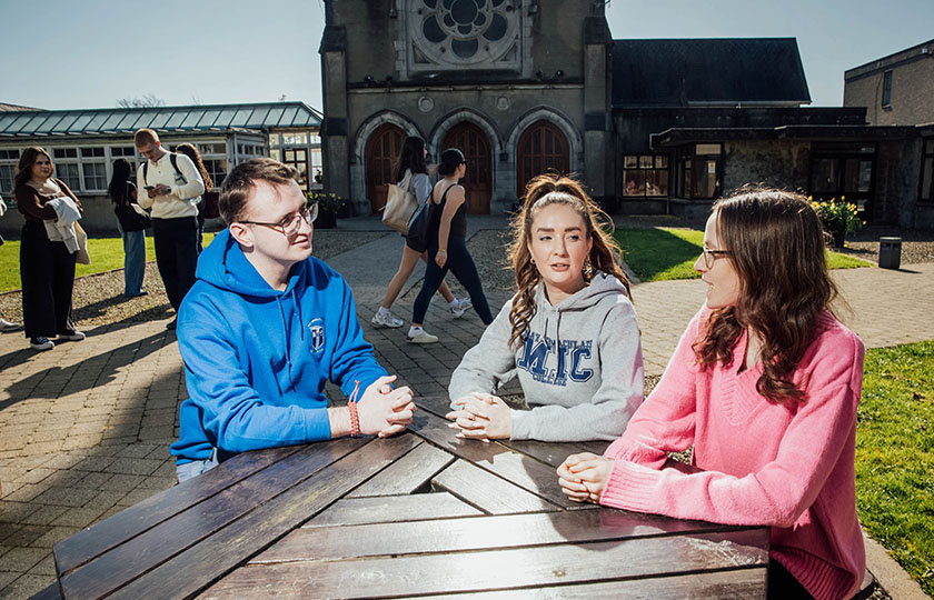 Students sitting at a table in the Quad in MIC