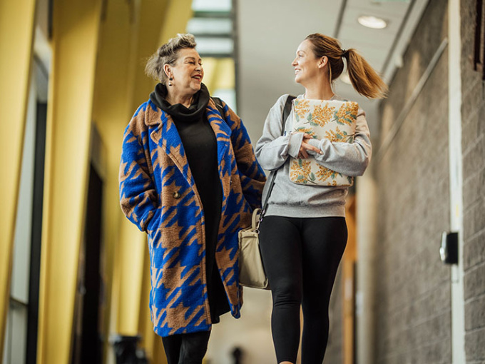 Two mature students walking in the hallway of the TARA building