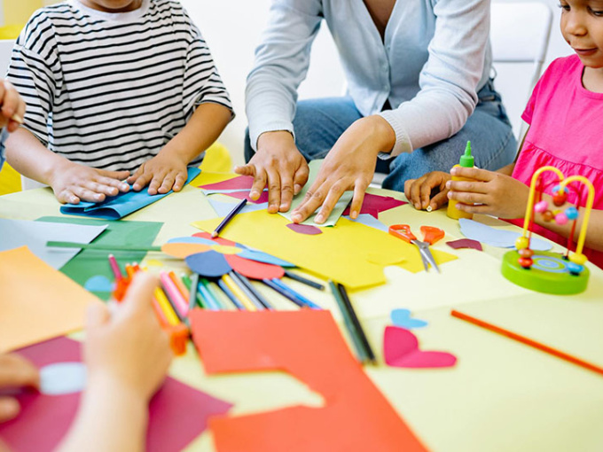 Preschool kids sitting around a table with their teacher